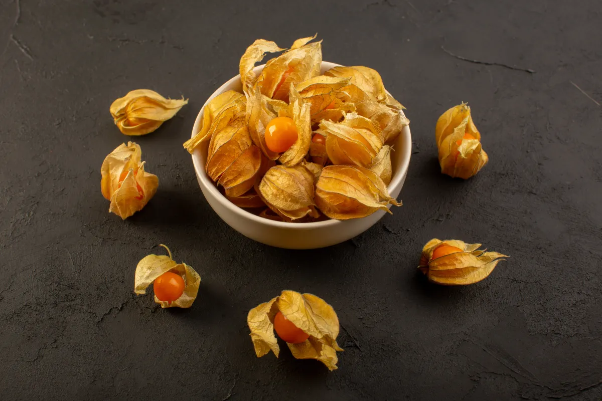 Close-up of ripe ground cherry fruits in husks arranged in a bowl, symbolizing natural skincare nutrition.
